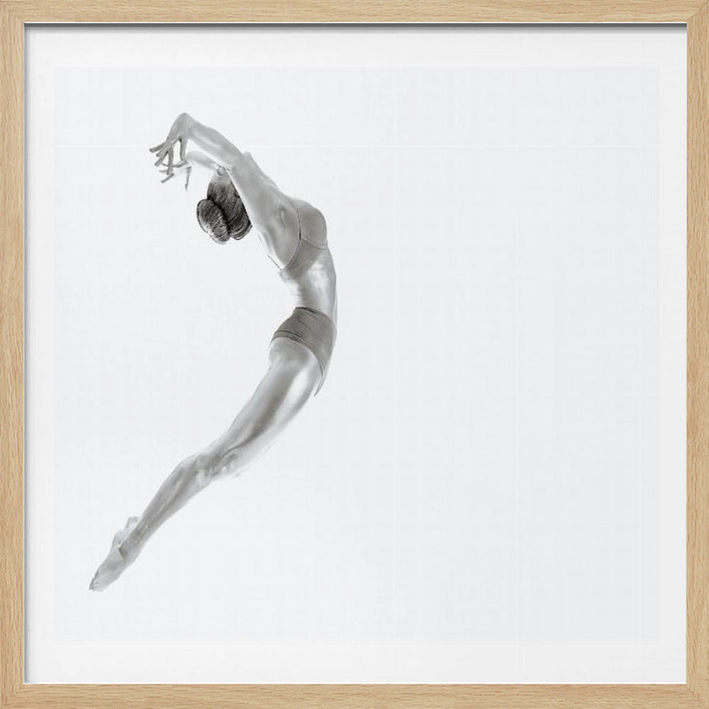 A minimalist black and white photograph of a graceful dancer frozen in mid-air, her body arched backward in an elegant C-shape against a stark white background. The artwork is presented in a light wood frame. Decor