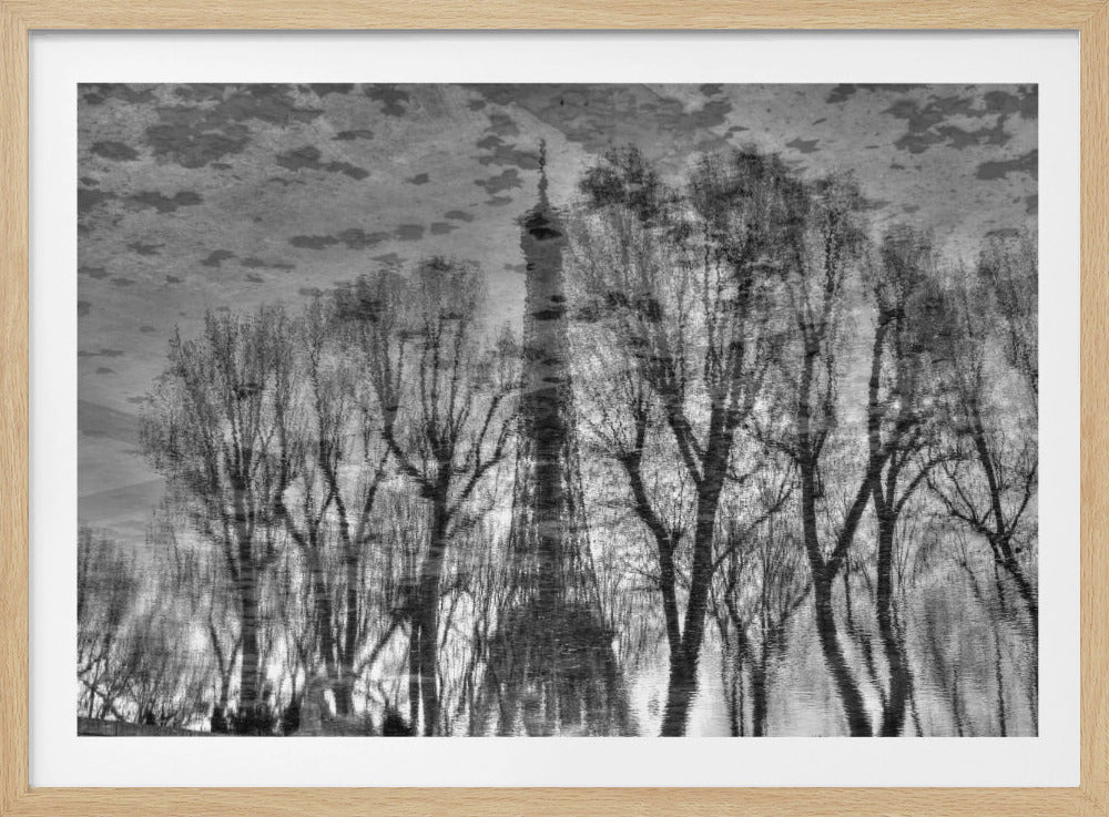 A moody black and white framed artwork depicting the rippling water reflection of the Eiffel Tower seen through a line of bare winter trees. The image is inverted, creating an abstract and dreamlike cityscape. Print