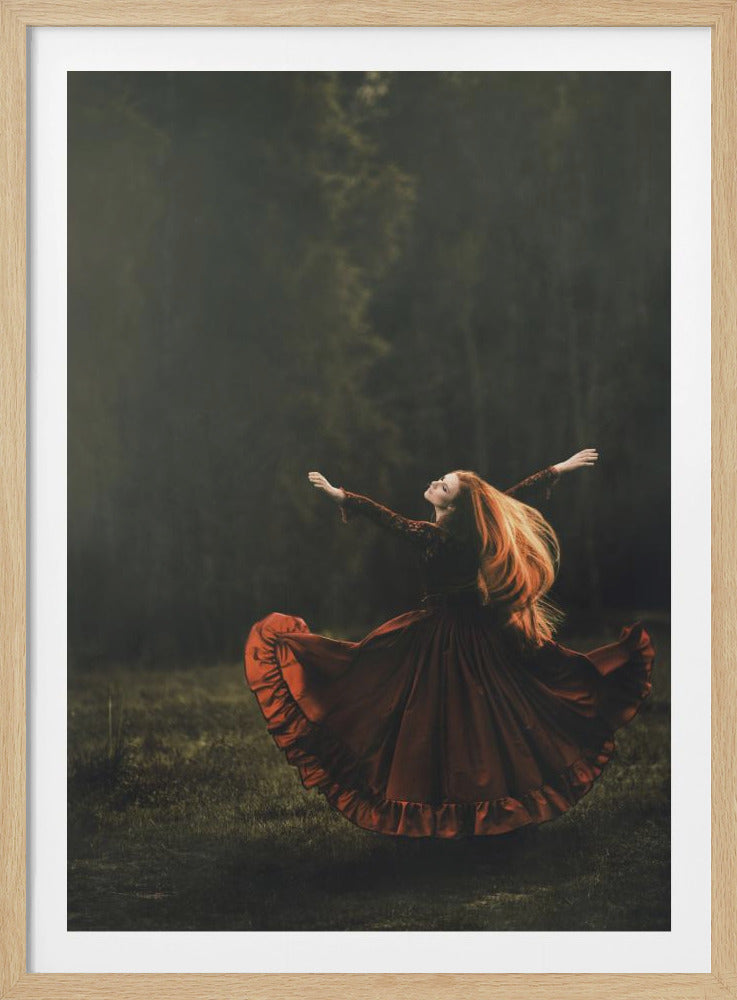 A woman with long, flowing red hair wearing a dark red, ruffled dress is twirling in a grassy field. Her arms are outstretched and her head is tilted back in a joyful pose. The background is a dark, moody, and misty forest. Poster