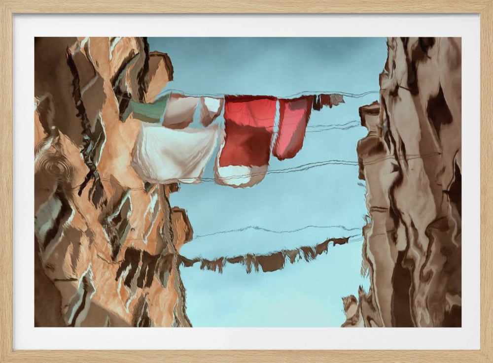 An abstract framed artwork showing the reflection of buildings and a clothesline in rippling water. The distorted, painterly reflections of brown buildings are on the left and right, framing a light blue center where red and white laundry hangs on a line. Wall Art