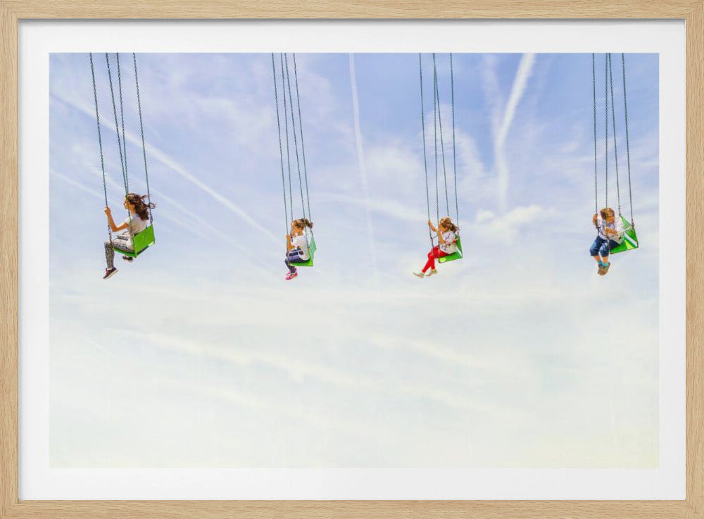 Four children ride high in the air on a green-seated chain swing ride, scattered against a vast, bright blue sky with white clouds and jet streams. The image is presented within a silver frame. Wall Art