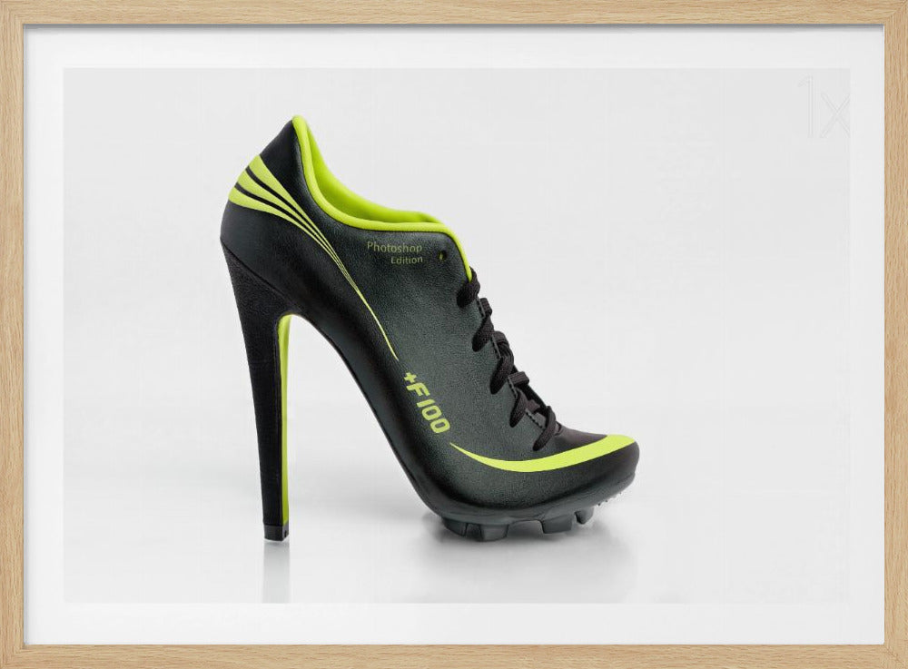 A conceptual piece of digital art featuring a hybrid shoe that is part black soccer cleat and part stiletto high heel. The shoe has neon lime green accents and is displayed against a stark white background inside a silver frame. Decor