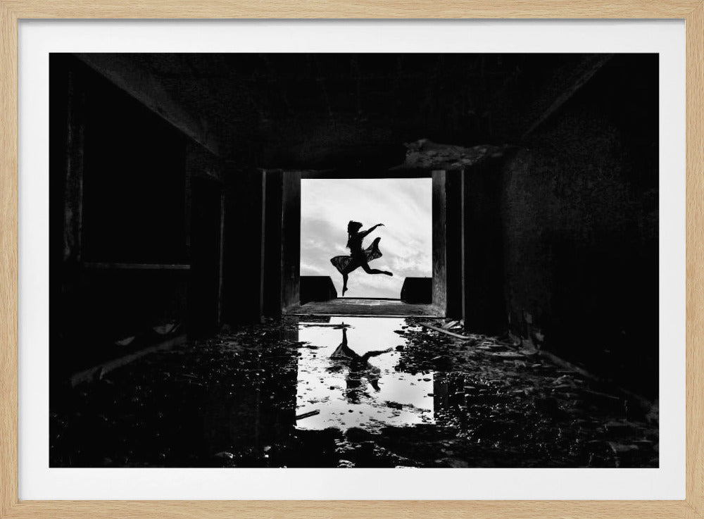 A dramatic black and white photo of a silhouetted dancer leaping in a bright doorway, viewed from inside a dark, derelict building. The dancer's reflection is captured in a puddle on the rubble-strewn floor. Poster