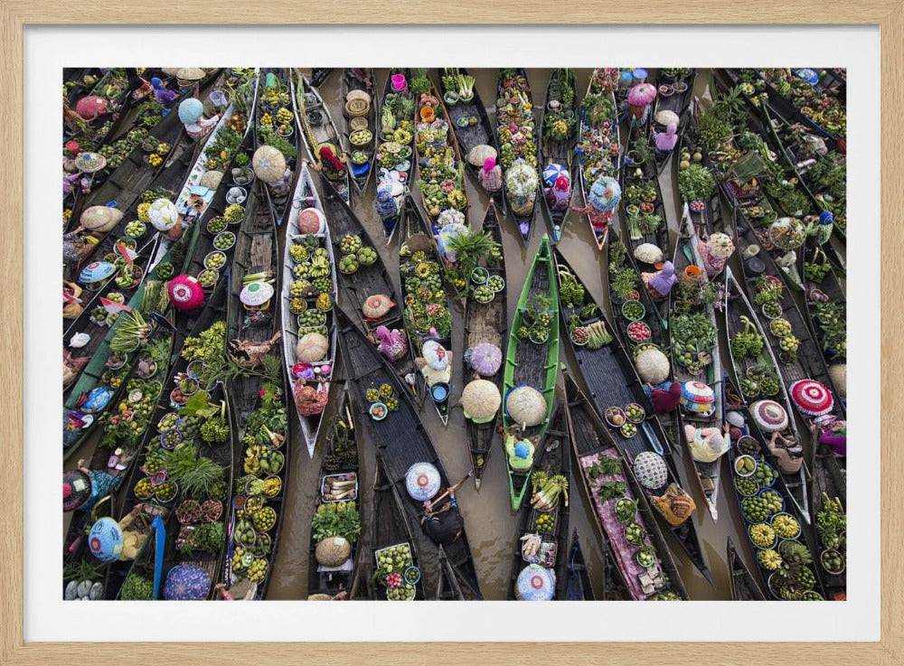 An aerial photograph of a crowded floating market in Southeast Asia, with dozens of narrow wooden boats filled with vibrant green produce and colorful wares on a brown river. Poster