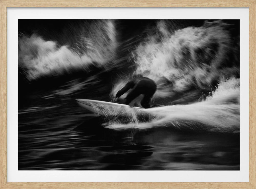A dynamic black and white action photograph of a surfer in a dark wetsuit, crouched low on a surfboard while riding a powerful wave. Motion blur captures the speed and energy of the moment, with white water spray exploding around the surfer against the dark ocean. Print