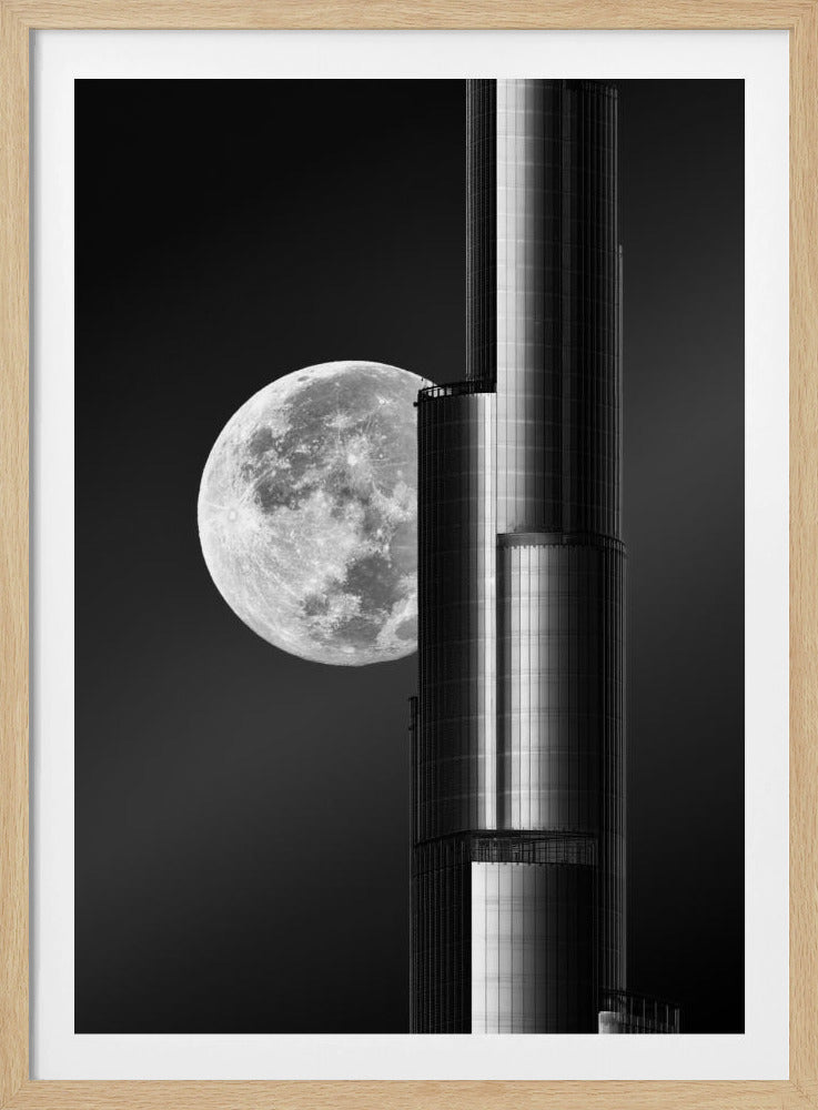 A dramatic black and white photograph of a massive full moon positioned next to a modern, towering skyscraper. The high-contrast image creates a striking juxtaposition between the natural celestial body and the man-made architectural marvel against a dark night sky. Poster