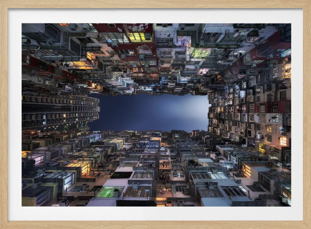 A striking low-angle photograph looking up from a narrow courtyard at the night sky, completely framed by towering, densely packed, and weathered apartment buildings with glowing windows, creating a sense of urban enclosure. Decor