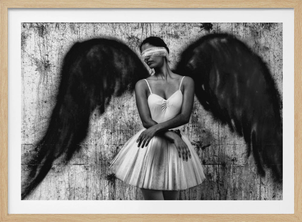A striking black and white portrait of a blindfolded woman dressed as a ballerina, standing against a gritty, textured wall with large black angel wings spray-painted behind her. Print