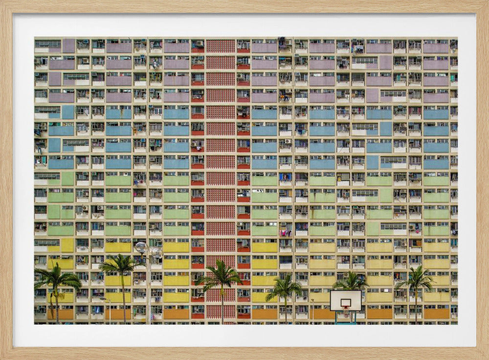 A symmetrical, frontal photograph of the colorful Choi Hung Estate in Hong Kong, featuring a massive grid of apartments with balconies painted in a rainbow of pastel colors including purple, blue, green, yellow, and orange. Palm trees and a basketball court are visible at the base of the building, which is enclosed in a silver frame. Wall Art