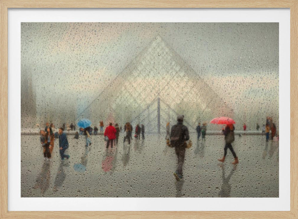 An impressionistic photograph of the Louvre Pyramid in Paris on a rainy day, viewed through a window covered in water droplets. The scene is blurred, with silhouettes of people walking with colorful umbrellas, all framed by a silver border. Print