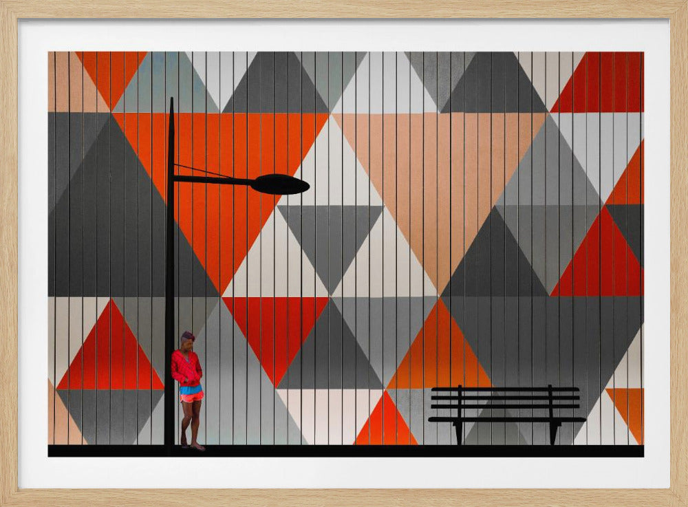 A modern art piece featuring a person in bright pink and blue clothing standing beside a black lamppost against a wall with a bold geometric triangle pattern. The pattern uses shades of orange, red, grey, and white. A silhouetted black bench sits on the right, and the entire image is bordered by a silver frame. Wall Art