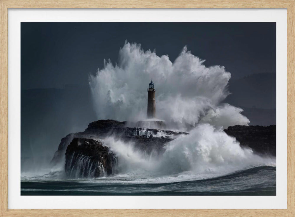 A dramatic photograph of a tall, slender lighthouse standing resolute on a dark, rocky island as a massive white wave explodes behind it, dwarfing the structure against a stormy, dark grey sky. Poster