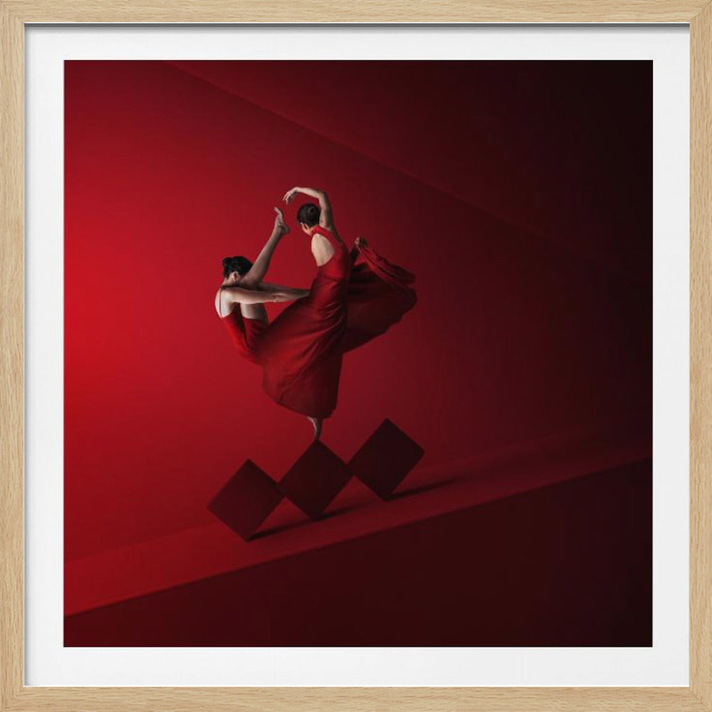 A surreal, artistic photograph of two women in flowing red dresses, locked in an elegant dance pose. They are impossibly balanced on the points of three red diamond-shaped blocks against a minimalist, monochromatic deep red background with soft lighting. Print