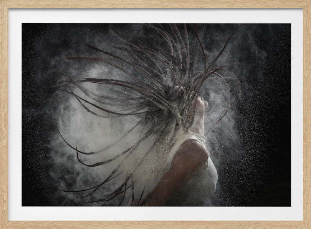 A dramatic black and white photograph of a person with long dreadlocks whipping their hair back, creating an explosion of white powder against a dark background, all within a silver frame. Print