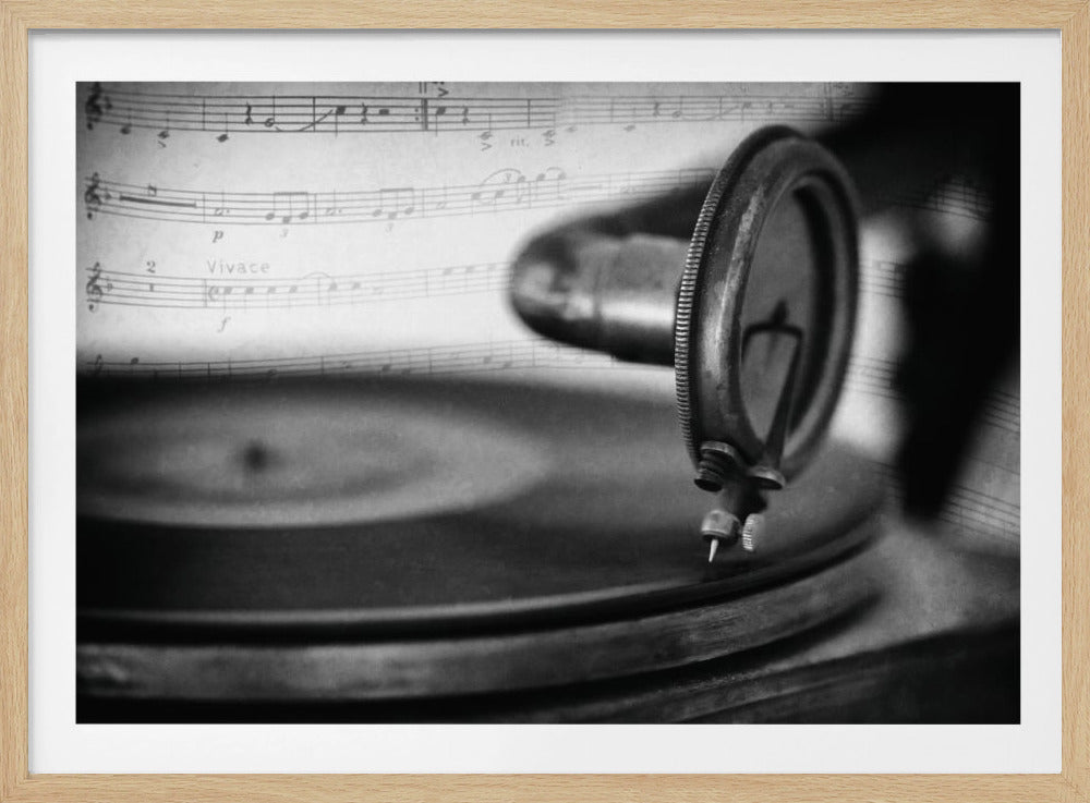 A close-up, black and white artistic photograph of a vintage gramophone needle and soundbox positioned over a record, with a translucent overlay of classical sheet music. The image has a textured, nostalgic feel and is set within a silver frame. Wall Art