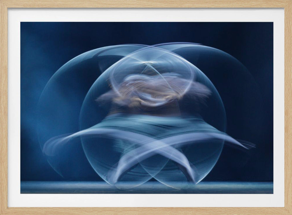 An abstract long-exposure photograph of a spinning dancer, creating ethereal, intersecting trails of blue and white light that form a glowing, orb-like shape against a deep blue background. The image is presented within a silver frame. Poster