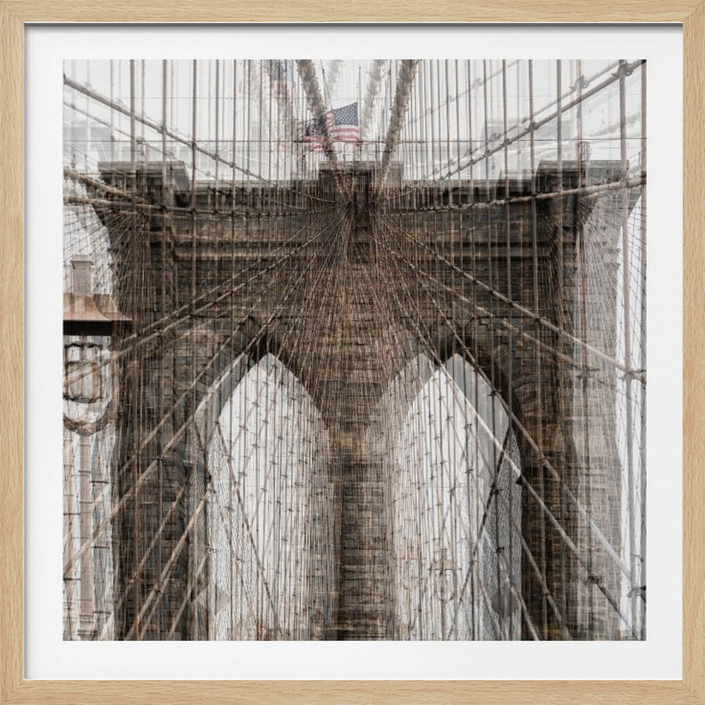 A framed abstract photograph of the Brooklyn Bridge, created with a double-exposure effect that overlays multiple views of the bridge's stone towers and intricate web of suspension cables, with an American flag visible at the top. Wall Art