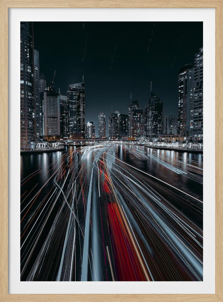 A dynamic long-exposure photograph of a bustling city marina at night. In the foreground, vibrant streaks of red and white light from moving boats cut across the dark water. In the background, a modern skyline of illuminated skyscrapers stands against a dark night sky, creating a futuristic and energetic scene. Poster