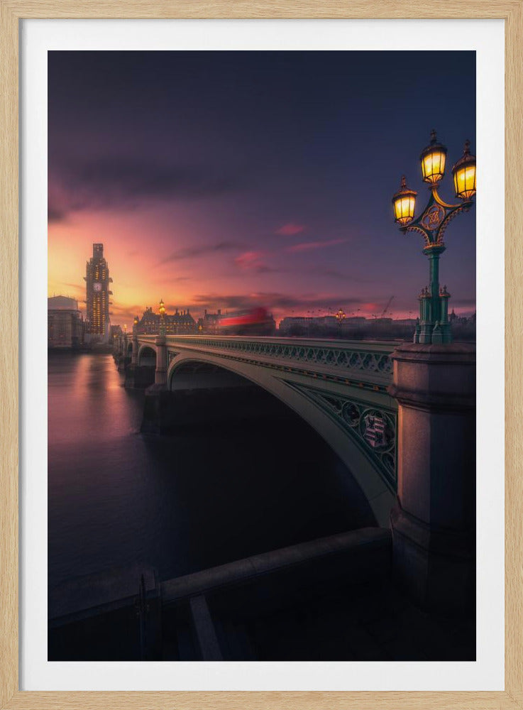 A breathtaking twilight view of Westminster Bridge in London, with the iconic Big Ben illuminated in the background against a purple and orange sunset sky. A vintage street lamp glows warmly in the foreground, and the motion blur of a red bus crosses the bridge over the calm River Thames. Print