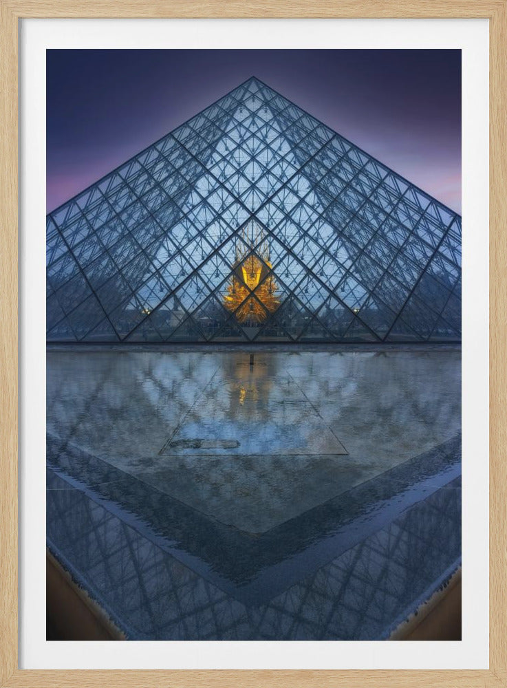 A symmetrical, frontal photograph of the glass Louvre Pyramid at dusk, with a golden light shining from its center. The pyramid and the purple sky are reflected in the wet ground in the foreground. Artwork