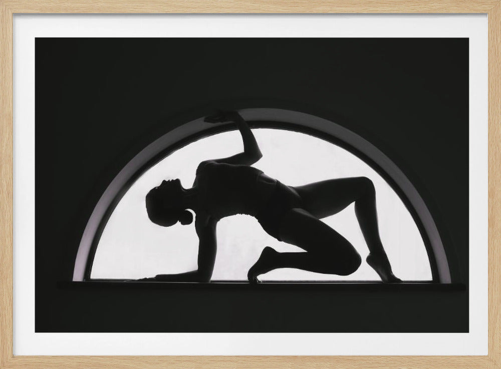 A striking black and white photograph showing the silhouette of a woman in a graceful, contorted pose within a brightly lit arched window. The entire piece is set within a silver frame. Wall Art