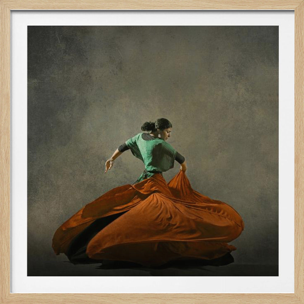 A framed artwork of a woman dancing against a dark, textured background. She wears a green top and a large, flowing burnt-orange skirt that billows out around her in a dynamic motion. Decor