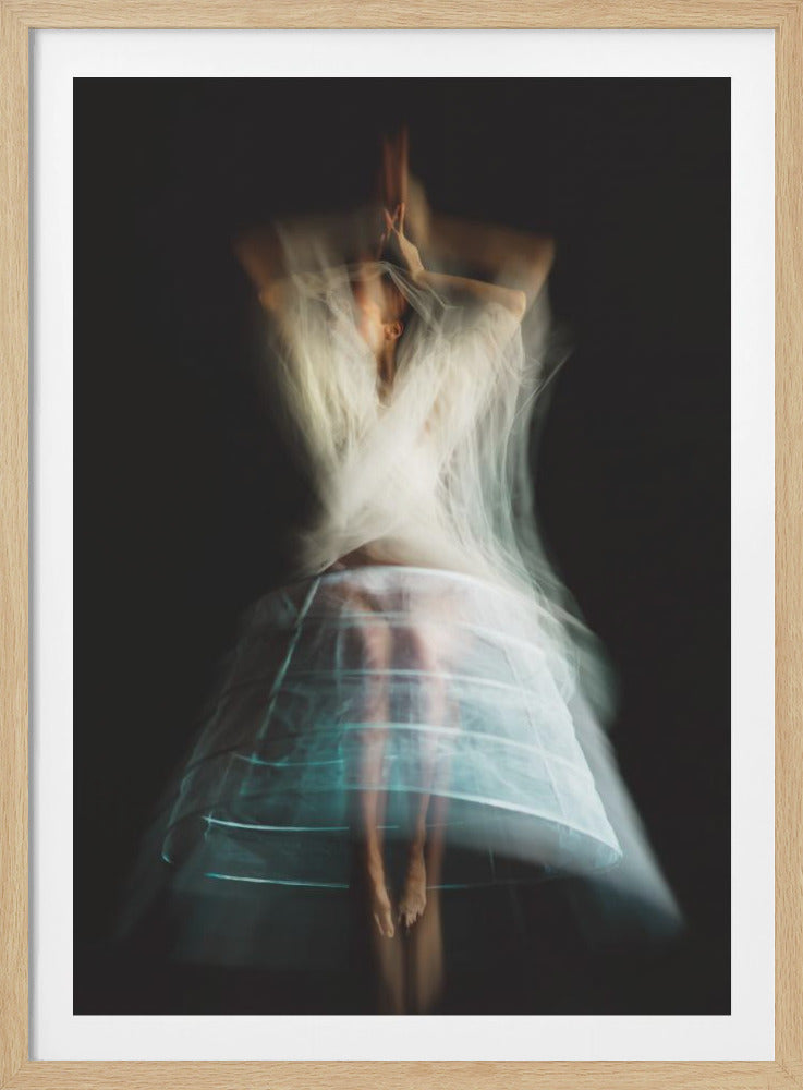 An ethereal, long-exposure photograph of a dancing figure against a dark gray background. The motion blur creates a ghostly effect, with white, gauzy fabric swirling around the upper body. The figure wears a transparent crinoline hoop skirt, revealing her legs and feet. Artwork