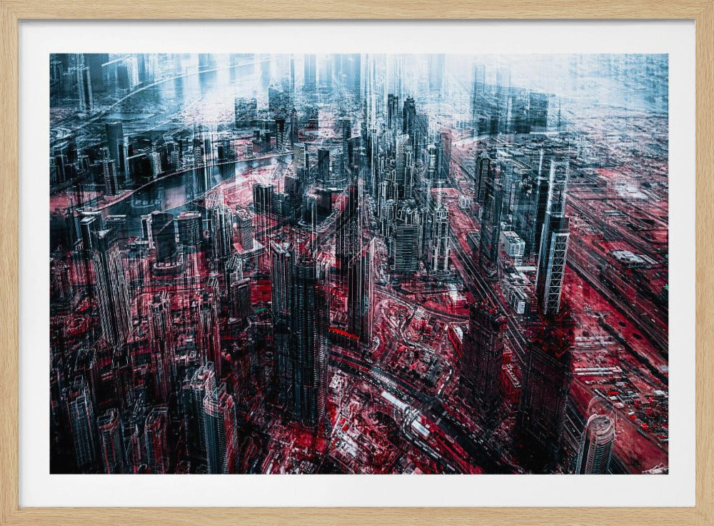 An abstract, digitally manipulated aerial photograph of a dense, futuristic cityscape. The image features towering skyscrapers in cool blue and dark gray tones, while the streets and ground below are saturated in a vibrant, contrasting red. The artwork has a glitchy, multi-exposure effect, creating a sense of dynamic chaos, and is enclosed in a silver frame. Artwork