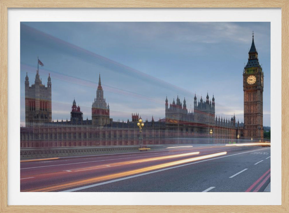 A framed, long-exposure photograph of London's Big Ben and the Houses of Parliament at dusk. In the foreground, streaks of red and yellow light from moving traffic blur across a bridge, creating a dynamic contrast with the historic architecture against a twilight sky. Decor
