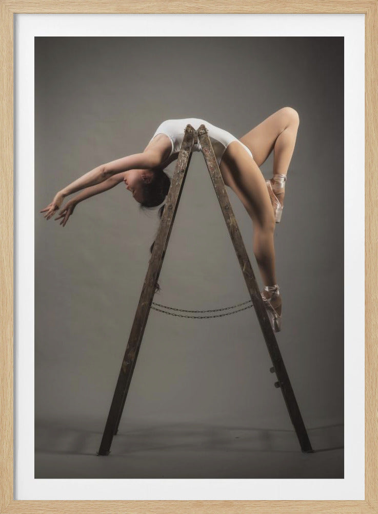 A graceful ballerina in a white leotard and pink pointe shoes performs an extreme backbend over the apex of a rustic wooden ladder against a plain grey studio background. Poster