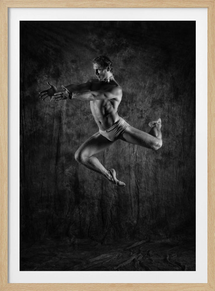 A dramatic black and white studio photograph of a muscular male ballet dancer captured mid-air, his body twisted in a graceful and powerful leap against a dark, textured backdrop. Wall Art