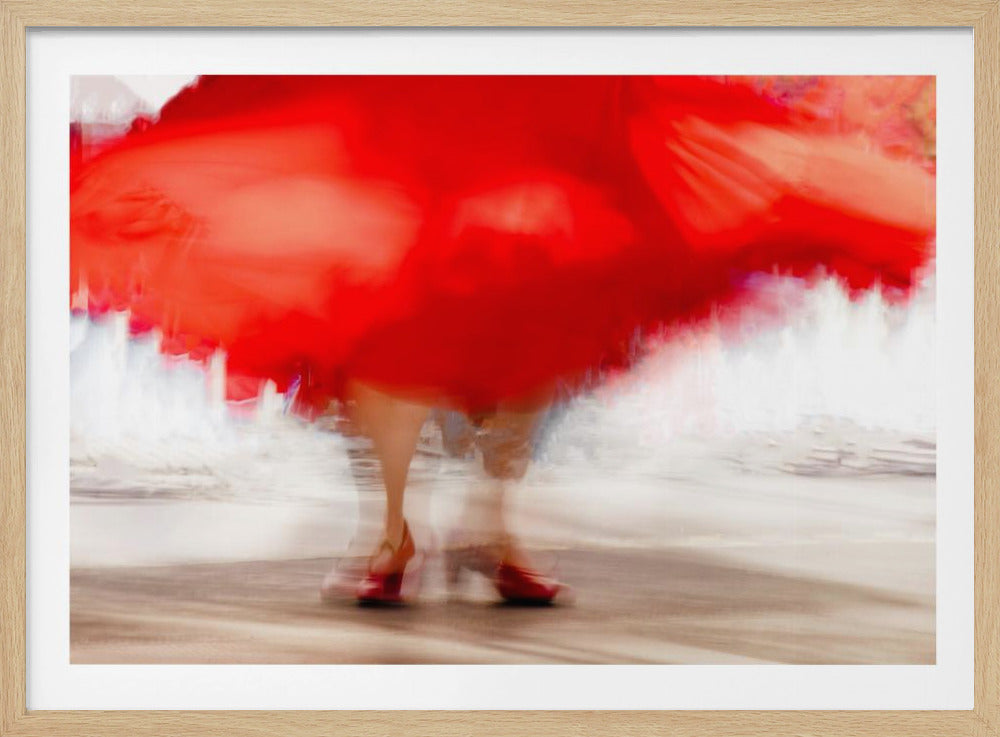 An abstract motion blur photograph of a dancer's lower half. A vibrant, swirling red skirt fills the top of the frame, while blurred legs and red high heels are visible at the bottom against a bright, hazy background. The entire image is contained within a silver frame. Wall Art