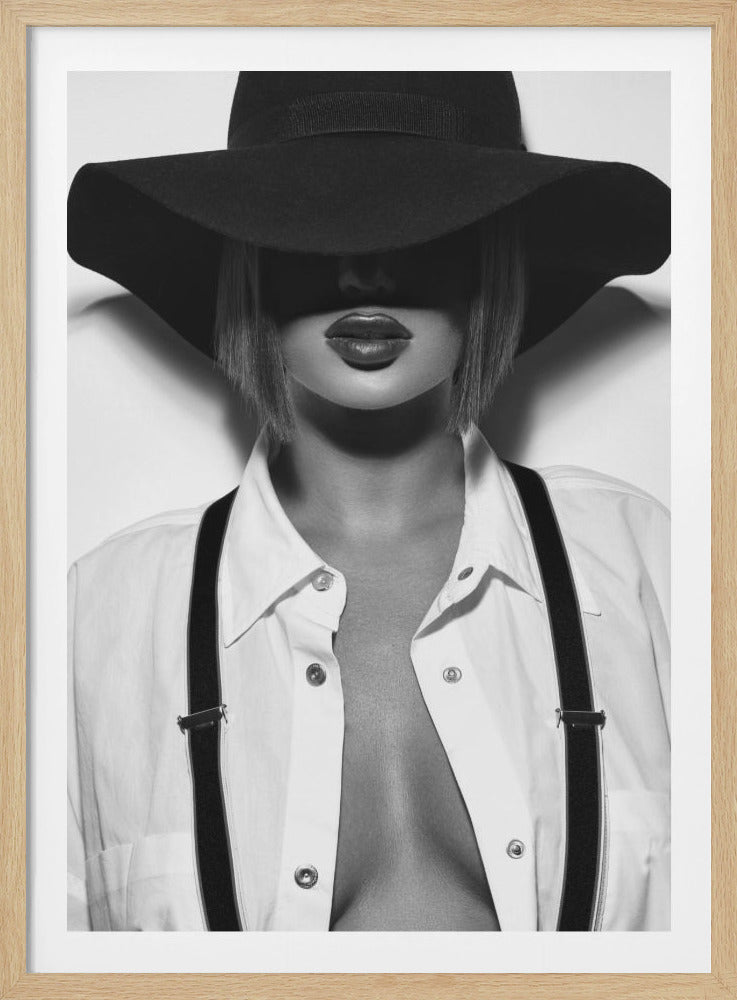 A black and white, framed portrait of a woman with a blonde bob. She is wearing a large, wide-brimmed black hat that casts a shadow over her eyes, leaving only her lips visible. She is dressed in an unbuttoned white shirt and black suspenders, creating a mysterious and chic look. Poster