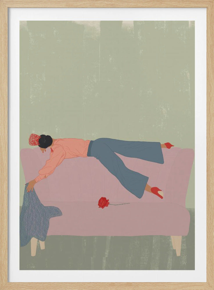 An illustration of a woman with dark hair in a bun, wearing a pink shirt, blue pants, and red heels, lying face down across a pink sofa. She reaches for a blue sweater on the floor, and a single red rose rests on the couch beside her. The background is a textured sage green, and the artwork is enclosed in a simple black frame. Artwork