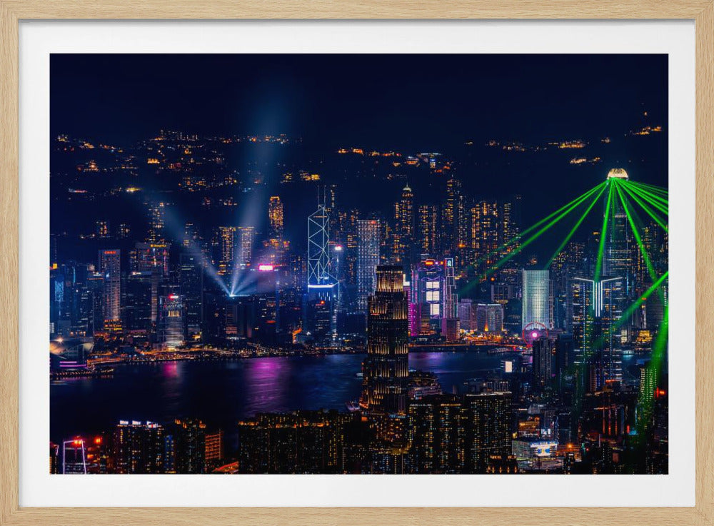 A framed photograph of the Hong Kong skyline at night, showcasing a vibrant display of illuminated skyscrapers and a spectacular green laser light show with beams crisscrossing the dark sky over the water. Poster