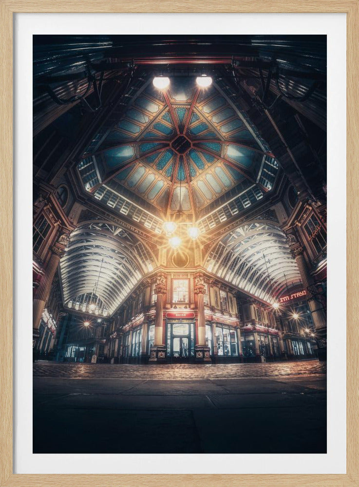 A dramatic, low-angle, wide shot of an empty Leadenhall Market at night. The ornate, domed ceiling is illuminated in blue and gold by bright, warm lights, which also cast a glow on the cobblestone floor and detailed Victorian storefronts. Wall Art