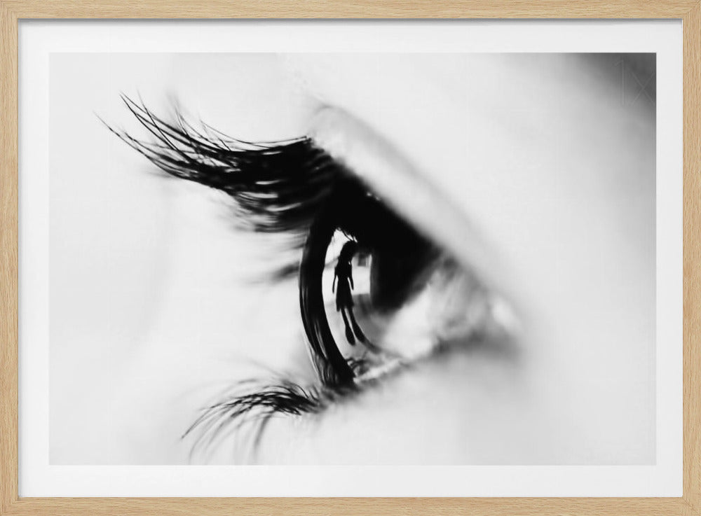 A dramatic black and white macro photograph of a human eye in profile, with a surreal reflection of a person's silhouette visible in the pupil. Print