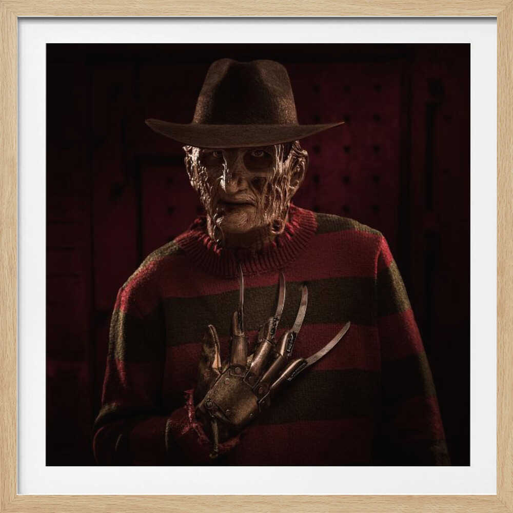 A framed portrait of the horror movie character Freddy Krueger, wearing his signature brown fedora, red and green striped sweater, and holding his bladed glove up to his chest in a menacing pose against a dark, shadowy background. Wall Art