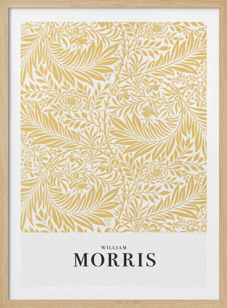 A framed exhibition-style poster of a William Morris design. The poster features an intricate, golden-yellow floral and leaf pattern on a white background. Below the pattern, the name 'WILLIAM MORRIS' is printed in black text. The entire artwork is presented in a simple black frame. Wall Art