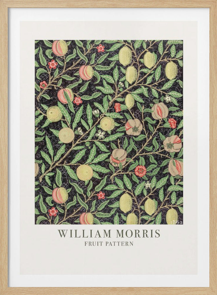 A framed art print of William Morris's 'Fruit Pattern,' featuring a dense, intricate design of lemons, pomegranates, and peaches amidst green leaves and small flowers on a dark background. The vintage Arts and Crafts style artwork has a white mat with the artist's name and title at the bottom. Decor