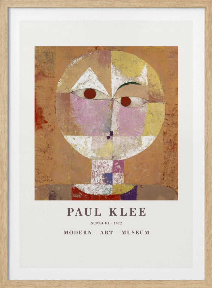 A framed museum poster of Paul Klee's 1922 painting 'Senecio'. The artwork is an abstract, geometric portrait of a human head in warm tones of orange, yellow, pink, and red against a textured brown background. The text 'PAUL KLEE', 'SENECIO - 1922', and 'MODERN - ART - MUSEUM' is printed below the image. Print