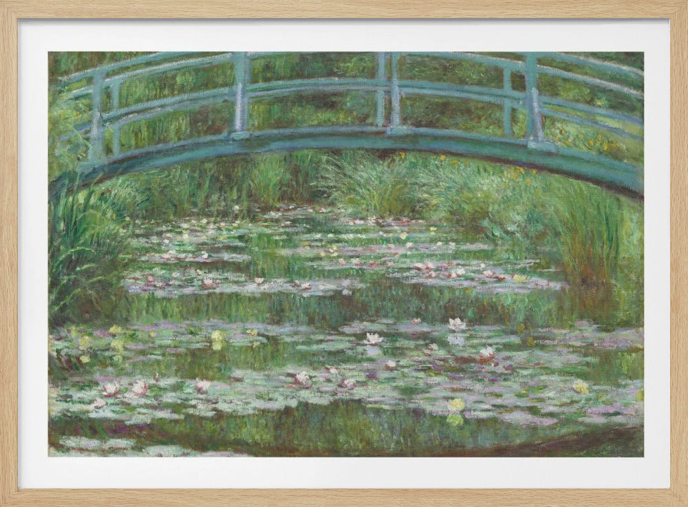 An Impressionist painting by Claude Monet depicting a green Japanese-style footbridge arching over a tranquil pond filled with blooming water lilies and lily pads, all rendered in soft, dappled brushstrokes and framed in a modern silver frame. Print