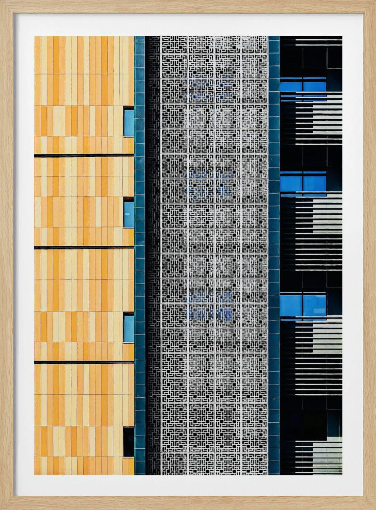A vertical abstract architectural photograph showcasing the facade of a modern building, featuring a contrast of textures and colors: warm yellow vertical tiles on the left, an intricate white geometric screen in the center, and a dark section with vibrant blue windows on the right. Print