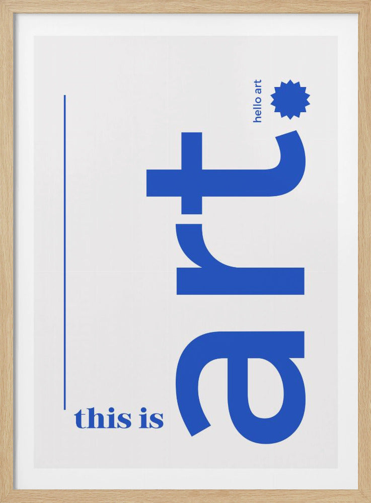 A minimalist art print in a black frame, featuring a white background with blue text. The word 'art' is written vertically in a large, bold lowercase font. To the left, smaller text reads 'this is'. At the top right, 'hello art' is written next to a blue starburst graphic. Wall Art