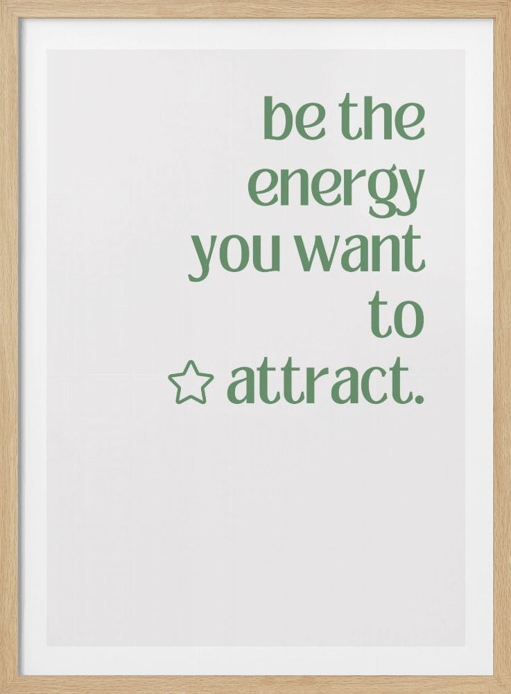 A framed minimalist art print featuring the motivational quote 'be the energy you want to attract.' The text is in a soft green, lowercase sans-serif font on a plain white background. A small outlined star icon precedes the word 'attract'. The entire piece is enclosed in a thin black frame. Poster