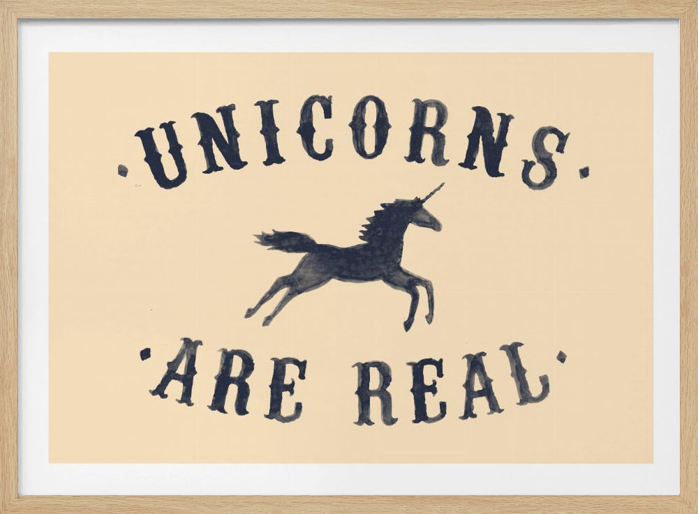 A framed art print with a cream background featuring the phrase 'UNICORNS. 'ARE REAL.' in a dark navy, vintage-style font. Between the words, there is a silhouette of a leaping unicorn. Print
