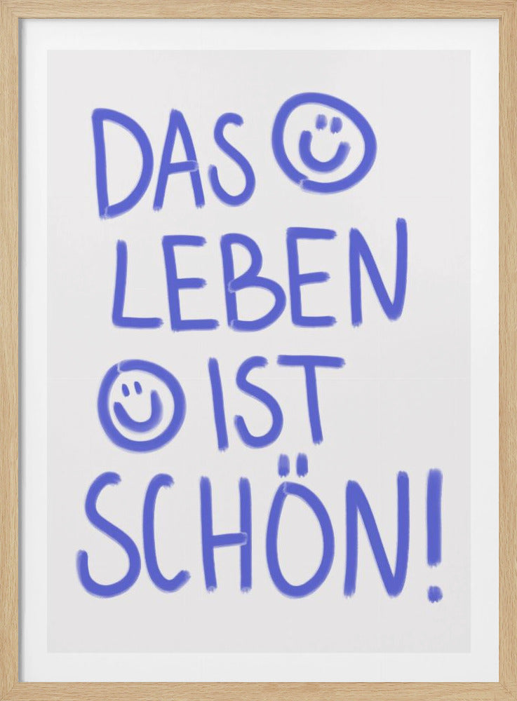 A typography poster in a black frame with the German phrase 'Das Leben ist schön!' handwritten in a playful blue font on a white background. The letter 'O' in 'DAS' is replaced with a smiley face, and another smiley face is drawn before the word 'IST'. Poster