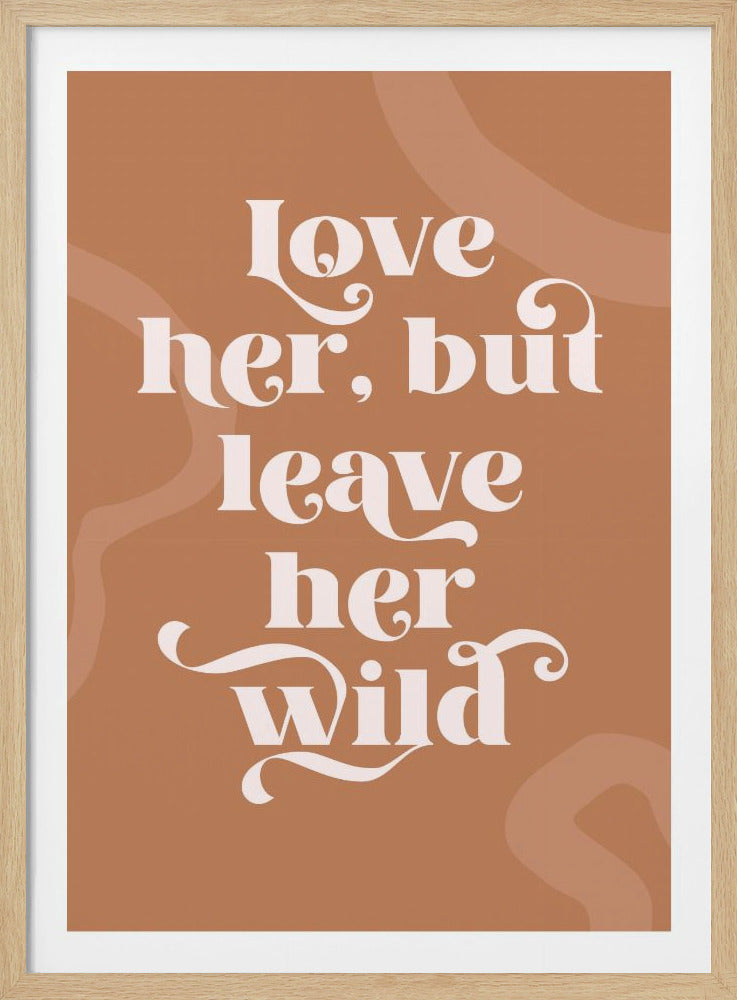 A framed typography poster with a terracotta brown background. In the center, the quote 'love her, but leave her wild' is written in a stylized, decorative, cream-colored font. Faint, lighter brown abstract shapes are visible in the background. Decor