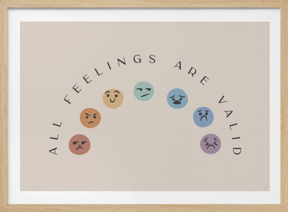 A framed art print on a beige background with the words 'ALL FEELINGS ARE VALID' in a black, arched text. Below the text is a corresponding arc of colorful emojis showing different expressions like happiness, anger, and sadness. Artwork