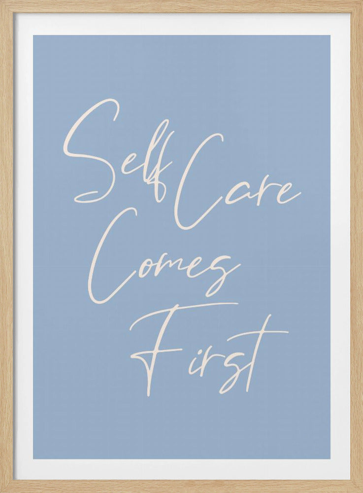 A framed poster featuring the phrase 'Self Care Comes First' in an elegant, off-white cursive font against a solid light blue background. The artwork is enclosed in a simple black frame. Decor